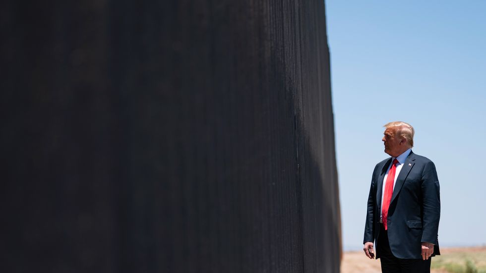 Donald Trump inspekterar muren han låtit bygga.