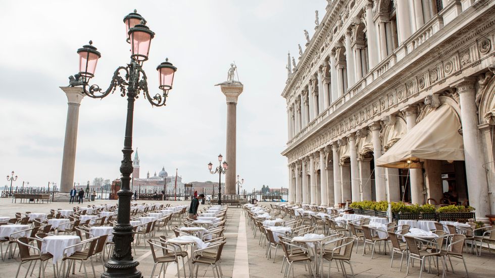 Restaurangpersonal förbereder en uteservering i Venedig i början av maj.
