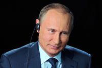 Vladimir Putin ler under tv-intervju i Moskva den 20 september.