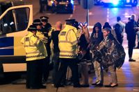 Räddningspersonal hjälper människor efter det misstänkta terrordådet i Manchester.