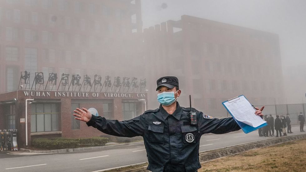 Kinesisk säkerhetspersonal motar bort journalister från högrisklabbet i Wuhan i samband med WHO-besöket i februari. 