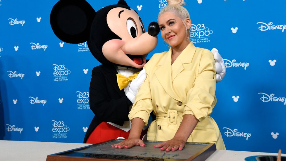 Sångerskan Christina Aguilera och Musse Pigg. Disney har nu släppt nya kvartalssiffror. Arkivbild.