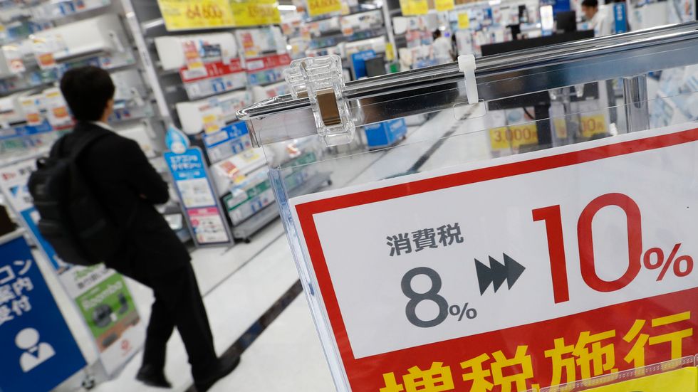 En elektronikhandel i Tokyo skyltar om inför den höjda momsen i landet i oktober.