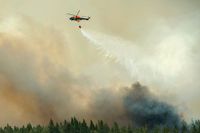En helikopter vattenbombar under skogsbranden i Västmanland 2014.