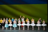 Kyiv Grand Ballet framför Ukrainas flagga efter sista föreställningen i mars i Frankrike. 