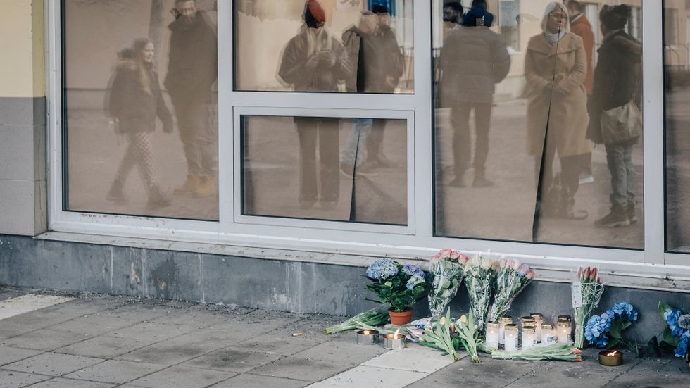Skjutningen inträffade inne på en restaurang i Skogås centrum. Utanför har människor lagt blombuketter och tänt ljus.