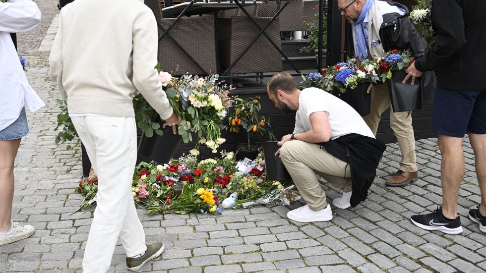Personer lägger ned blommor vid platsen där Ing-Marie Wieselgren mördades under Almedalsveckan. Arkivbild.