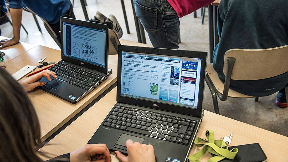 Elever jobbar med datorer i skolan.