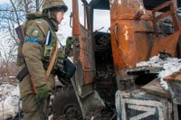 Ukrainsk soldat inspekterar ett utbränt ryskt arméfordon.
