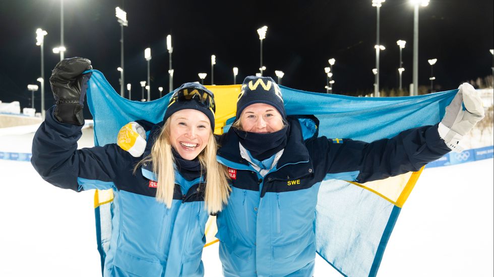 Silvermedaljören Maja Dahlqvist och guldmedaljören Jonna Sundling med svenska flaggan och OS-maskotar efter damernas sprint fristil under vinter-OS.