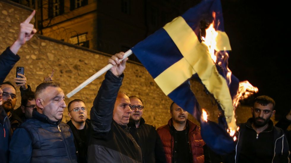 Demonstranter bränner den svenska flaggan utanför det svenska konsulatet i Istanbul.