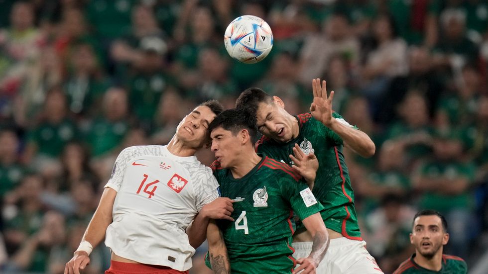 Spelare från Mexiko och Polen slår sina huvuden ihop i gruppspelet under VM i Qatar.