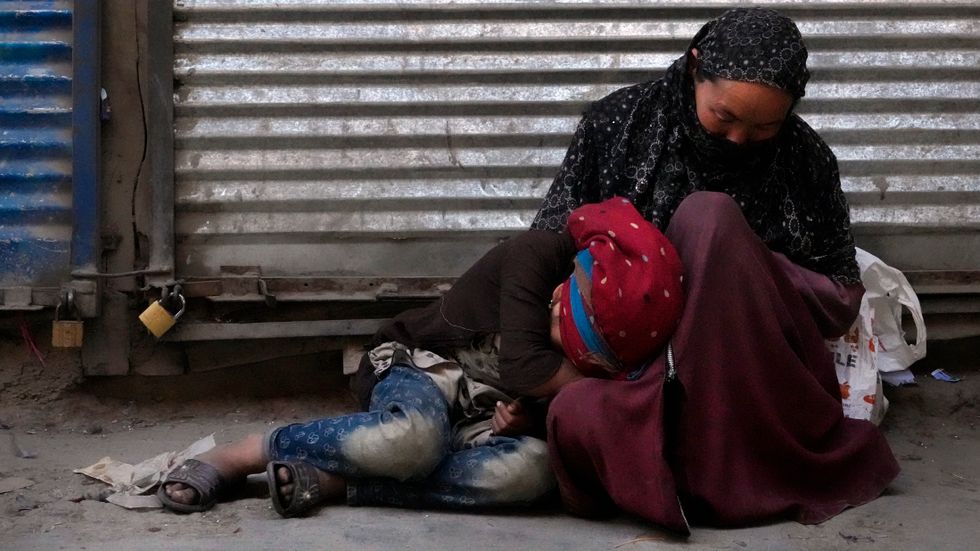 Kvinna tigger med sin dotter i Kabul. 