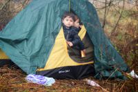 En pojke i ett migrantläger när Polens gräns.