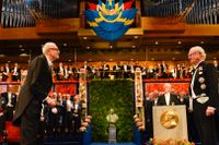 Förra årets litteraturpristagare Patrick Modiano tar emot nobelpriset av kungen.