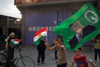 Barn viftar med kurdiska flaggor och flaggor med Massoud Barzani på i staden Kirkuk.