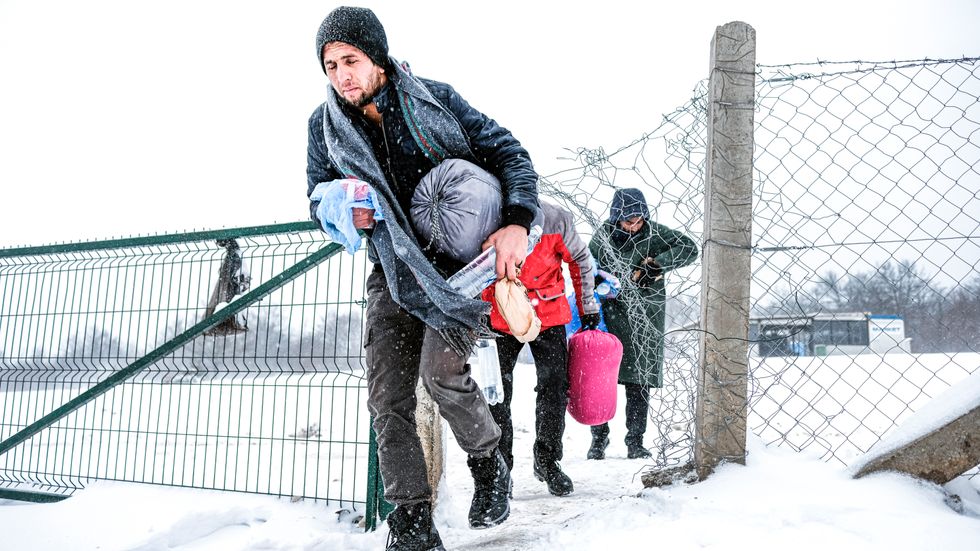 Migranter går genom snön i Lipa-lägret i nrordvästra Bosnien, vid gränsen till Kroatien.