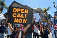Flera hundra personer samlades till protest mot corona-restriktionerna i Huntington Beach i Kalifornien på fredagen.