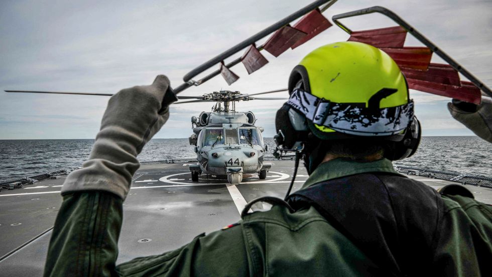 En tysk soldat signalerar till en amerikansk Seahawk-helikopter under 2022 års Baltops-övning.