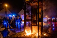Poliser vid en nedbränd telefonautomat i Derry, Nordirland. 