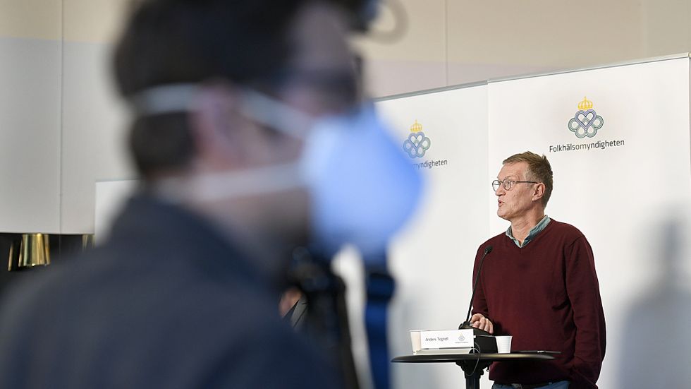 Statsepidemiolog Anders Tegnell under en pressträff. En journalist med munskydd i förgrunden. 