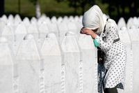 En kvinna lutar sig mot en gravsten i Potocari, nära Srebrenica, där 25-årsdagen av massakern där 8 000 muslimska män och pojkar dödades högtidlighölls.