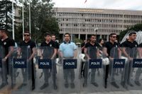 Turkiskt kravallpolis håller vakt utanför en domstol där eventuella kuppmakare förhörs.