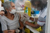 I Filippinerna håller nio miljoner människor på att vaccineras, efter att den nya omikronvarianten av coronaviruset upptäckts. På bilden får en kvinna sin spruta i staden Quezon.