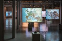 ”The Mapping Journey Project” i förgrunden fyller Färgfabrikens stora utställningssal. I bakgrunden visas ”The Speeches Series”  och ”The Constellation Series”, samtliga av Bouchra Kalili