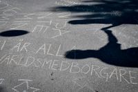 Manifestation mot nazism i form av ord skrivna med krita på asfalten på platsen där Nordiska Motståndsrörelsen (NMR) ska resa sitt tält. 