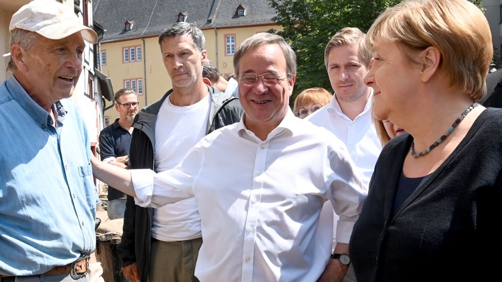 Angela Merkel och Armin Laschet. Bilden från i somras på en uppsluppen Laschet vid ett besök i översvämmade områden, anses vara en av anledningarna till hans impopularitet.