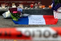 Blommor och ljus utanför reataurangen Le Carillon, en av platserna där terroristerna slog till i Paris.