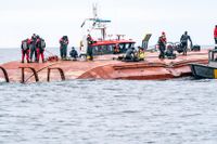 Dykare och personal från räddningstjänsten, sjöräddningen och kustbevakningen arbetar på det danska kapsejsade fartyget Karin Hoej.