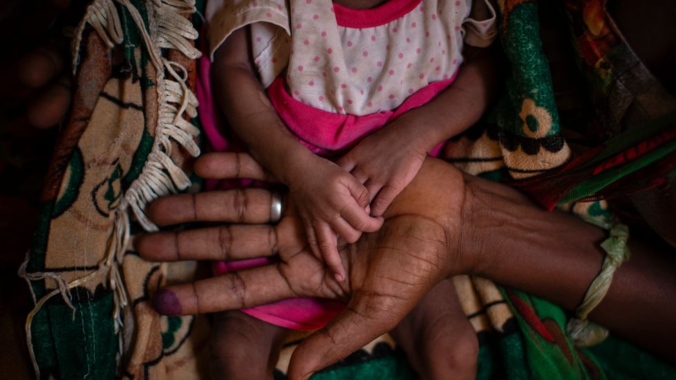 En mamma håller sin dotters händer i en by i Tigray-regionen i Etiopien.