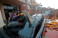 En kvinna betraktar sin demolerade bil sedan ett hotell kollapsat intill fordonet i Panama City när orkanen drog in över land.