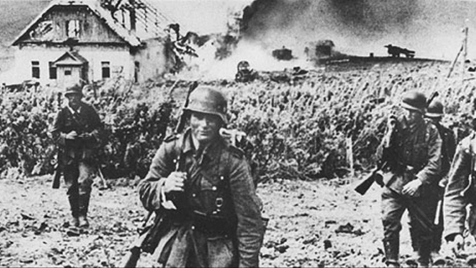Andra världskriget - Polen invaderas. Tyska trupper avancerar fram vid Kharkov fronten 1942. Brinnande hus i bakgrunden.