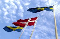 Dannebrogen omgiven av den svenska flaggan.