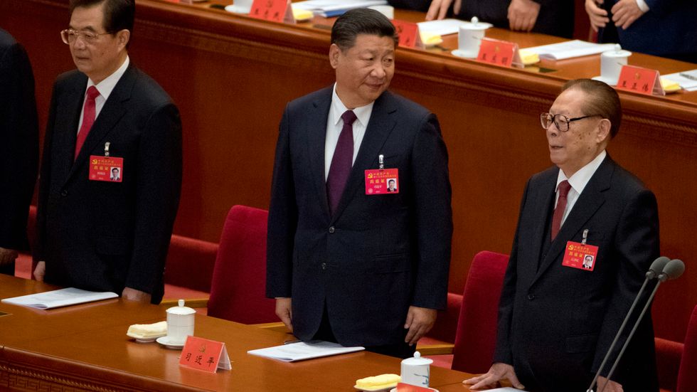 Kinas ledare Xi Jinping, omgiven av sina företrädare Hu Jintao (till vänster) och 91-årige Jiang Zemin. Den sistnämndes närvaro väcker uppseende, eftersom han nyligen ryktades ha avlidit.