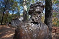Thoreau står kvar i brons framför en replik av sin hydda vid Walden pond, där han levde ensam 1845–1847.