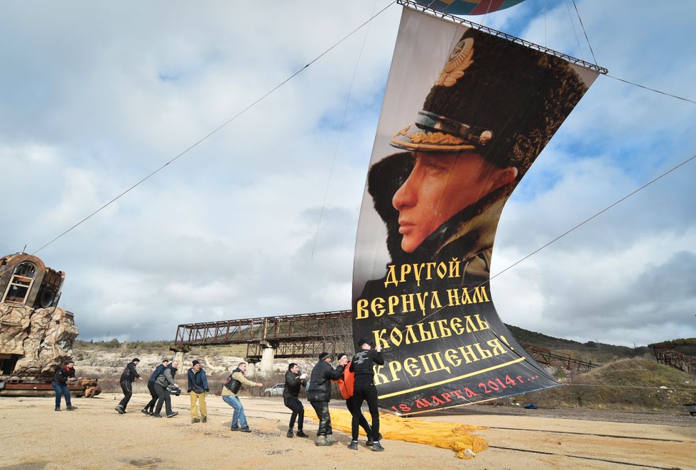 Ett stort porträtt av Vladimir Putin blir rest i Sevastopol, Krim, som Ryssland annekterade olagligt från Krim 2014.