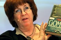 Frilansjournalisten Monica Antonsson håller upp ett välläst exemplar av första upplagan av Liza Marklunds bok ”Gömda” under tidskriften Neos debatt om boken i Stockholm.