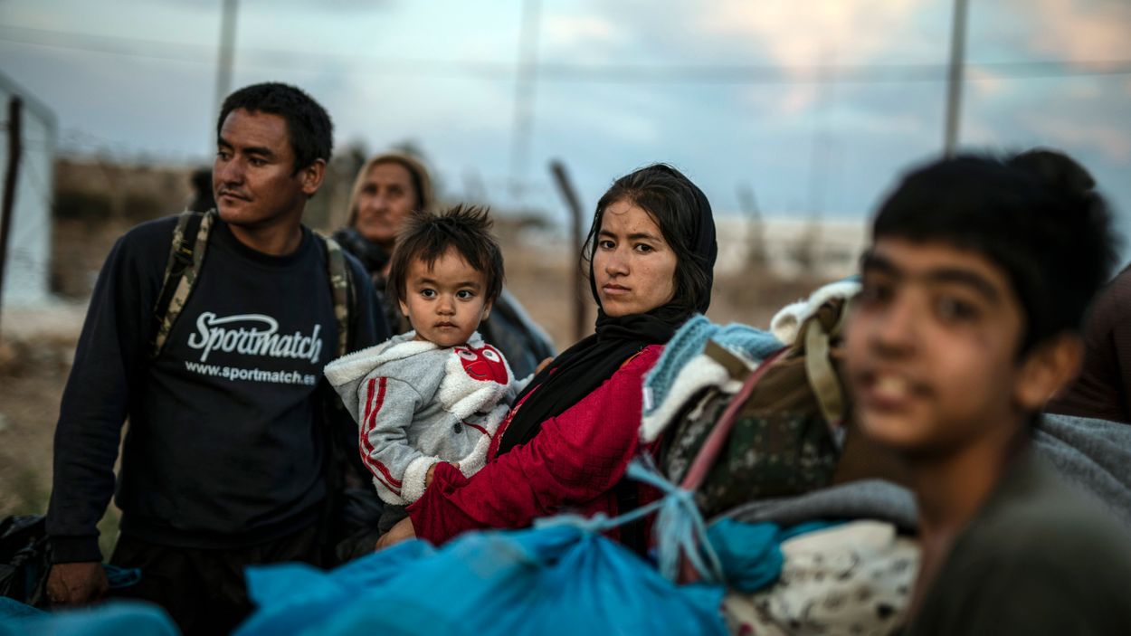 Flyktingar och migranter från det brandhärjade flyktinglägret Moria väntar på att få komma in i ett nytt temporärt flyktingläger på Lesbos.