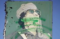 En skylt med Gaddafis porträtt, pepprad med kulor av hans motståndare vid stadsgränsen till Bani Walid.