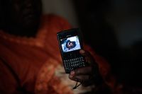 En kvinna visar en bild av sin eboladrabbade syster i Monrovia i Liberia. Mobiltelefoner och annan teknik är viktiga medel för att bekämpa utbrottet.