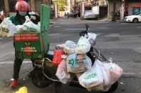 En man som arbetar för ett leveransbolag arrangerar beställda matkassar på sin moped i Jingan i västra Shanghai.