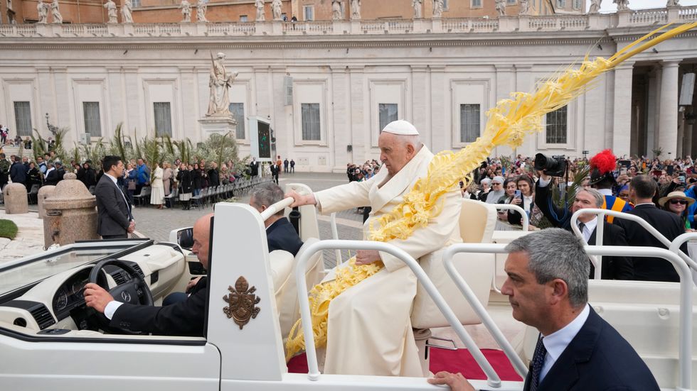 Påve Franciskus på sitt specialbyggda fordon på väg över Petersplatsen på palmsöndagen, dagen efter att han lämnat sjukhuset i Rom.