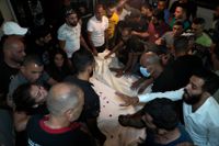 Människor sörjer två av de åtminstone 89 dödsoffren från en förlisning i östra Medelhavet. Bilden togs i Tripoli i norra Libanon på fredagen.