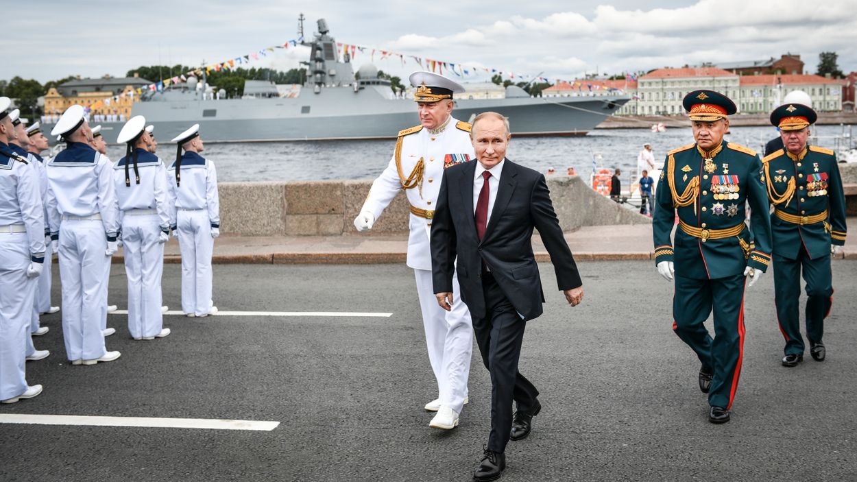 President Vladimir Putin tillsammans med marinens befälhavare Nikolai  Yevmenov (t v) och försvarsminister Sergej Sjojgu (t h) under ryska marinens parad i S:t Peterburg sommaren 2021.