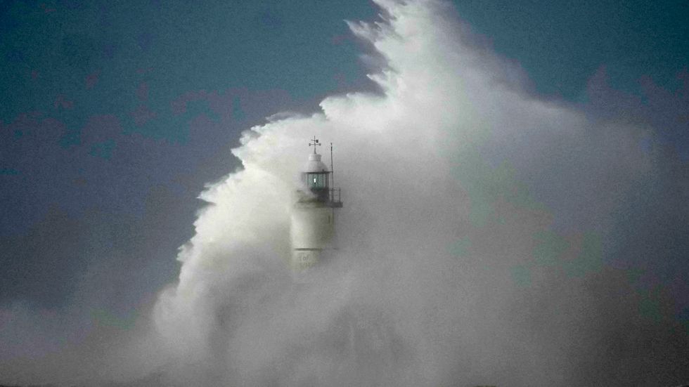 Vågor slår in över fyren i Newhaven på Englands sydkust på fredagen.