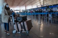 En resenär ska precis checka in på Pekings internationella flygplats under torsdagen. Nu vidtar en rad länder åtgärder för resenärer från Kina med anledning av den ökade smittspridningen i landet.